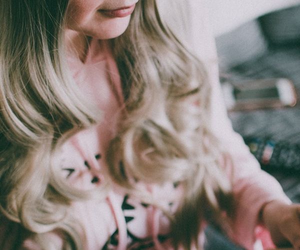 Person sitting peacefully with eyes closed in a calm setting.