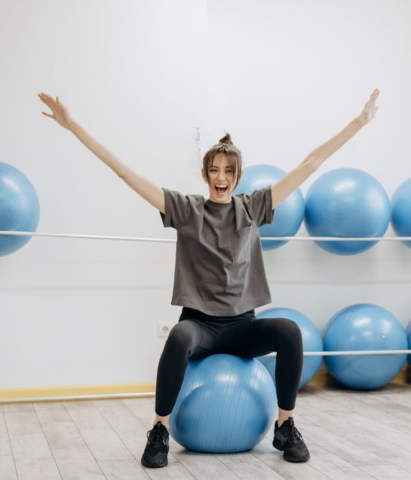 Woman doing a light stretching exercise in a bright room.